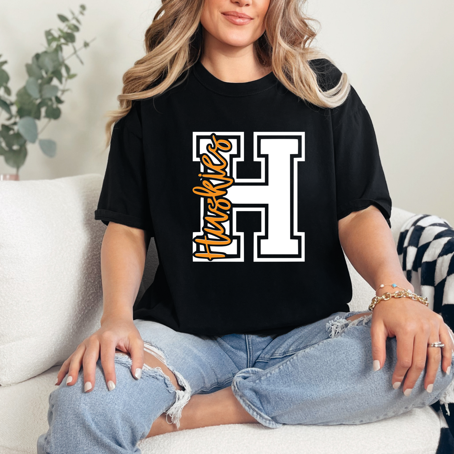 Woman wearing Hamilton Heights Huskies varsity H spirit wear shirt featuring classic varsity monogram design