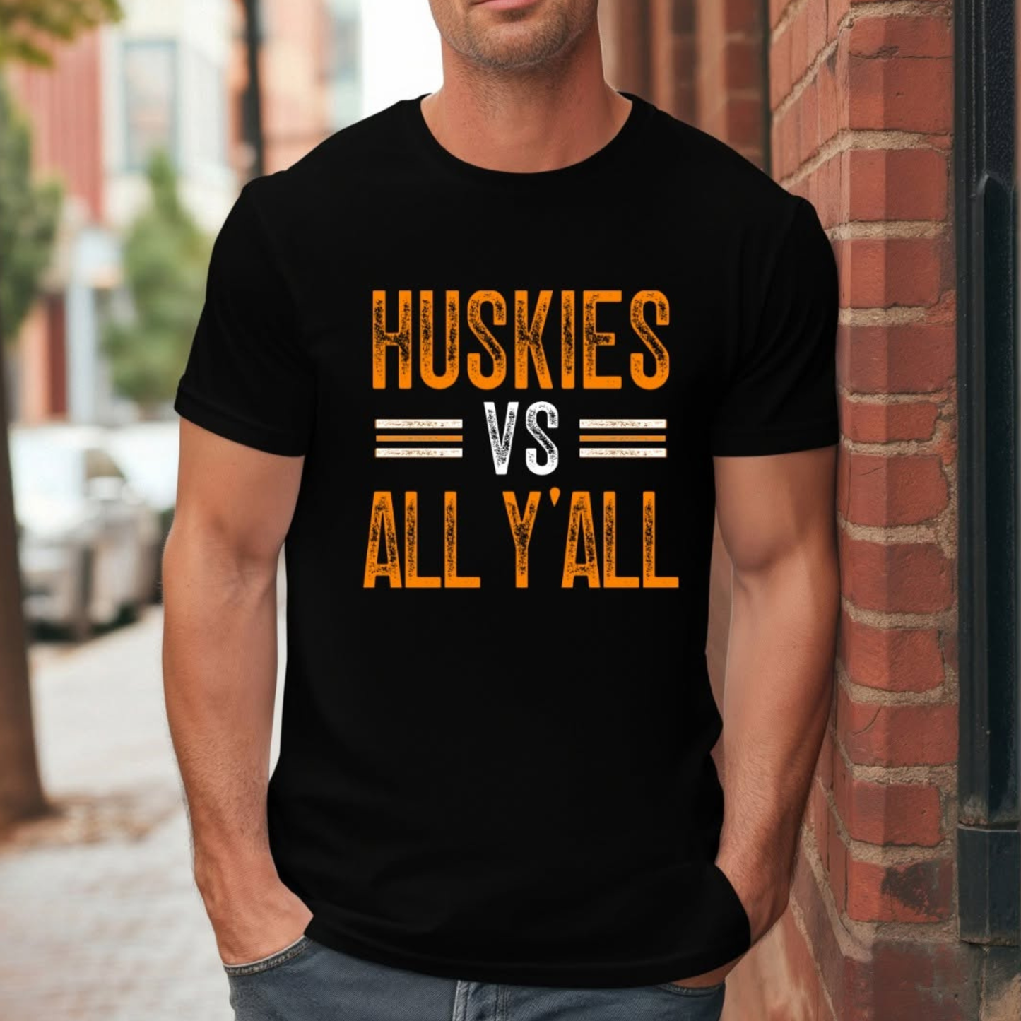 Man wearing Hamilton Heights Huskies vs All Y'all men's t-shirt featuring distressed orange and white game day graphic on black shirt