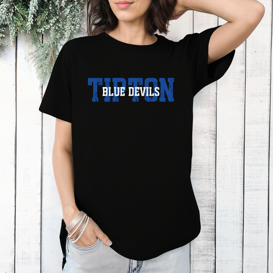 Woman wearing a black graphic t-shirt featuring a layered 'TIPTON BLUE DEVILS' design with bold lettering.