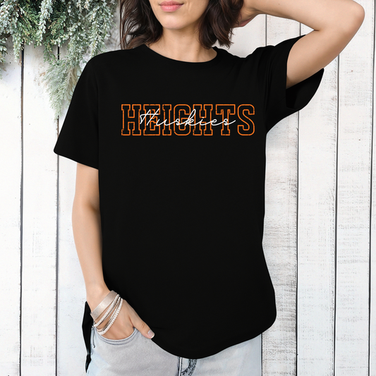 Person wearing a black t-shirt with a distressed orange 'HEIGHTS' design and white script 'Huskies' text layered on top.