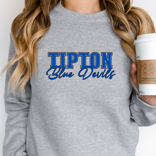 Woman wearing a gray sweatshirt with 'Tipton Blue Devils' text, holding a coffee cup.