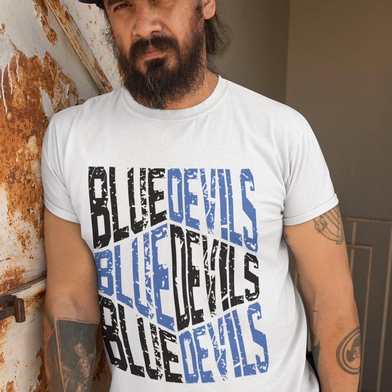 Man wearing a distressed Blue Devils stacked text graphic tee in school spirit colors.
