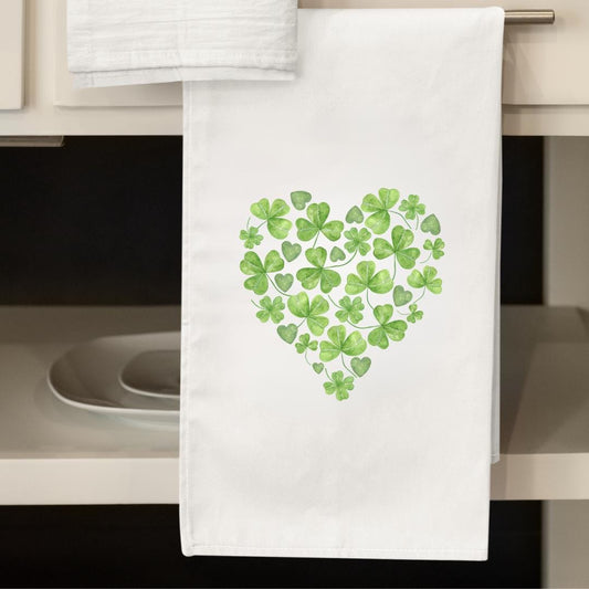 White flour sack towel featuring a heart shape made of clovers and hearts.