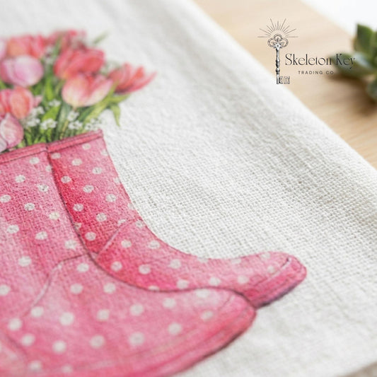 Pink polka dot boots with flowers on a white background, featuring the Skeleton Key Trading Co logo.