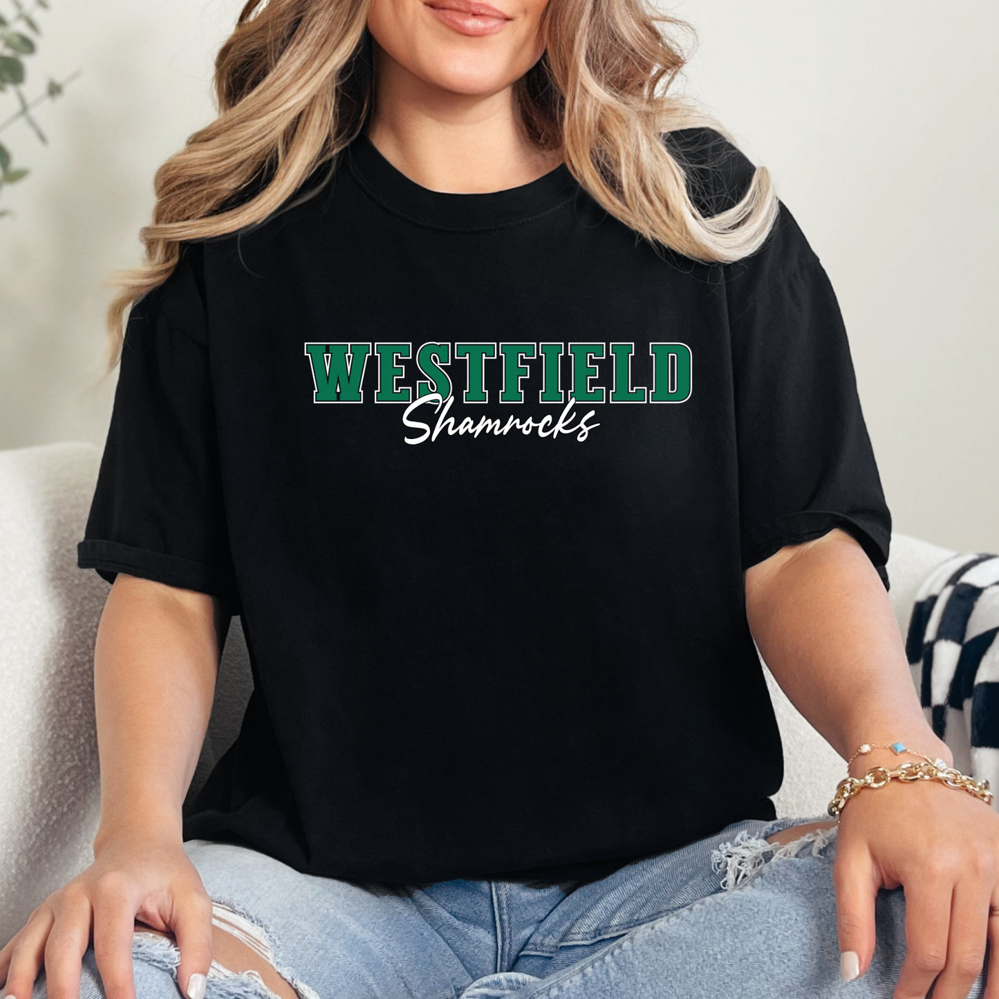Woman wearing a black Westfield Shamrocks Script Spirit Shirt featuring green varsity Westfield lettering with Shamrocks script design on a unisex t-shirt.