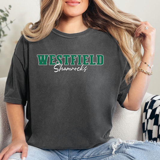 Woman wearing a dark grey Westfield Shamrocks Script Spirit Shirt featuring green varsity Westfield lettering with Shamrocks script design on a unisex t-shirt.