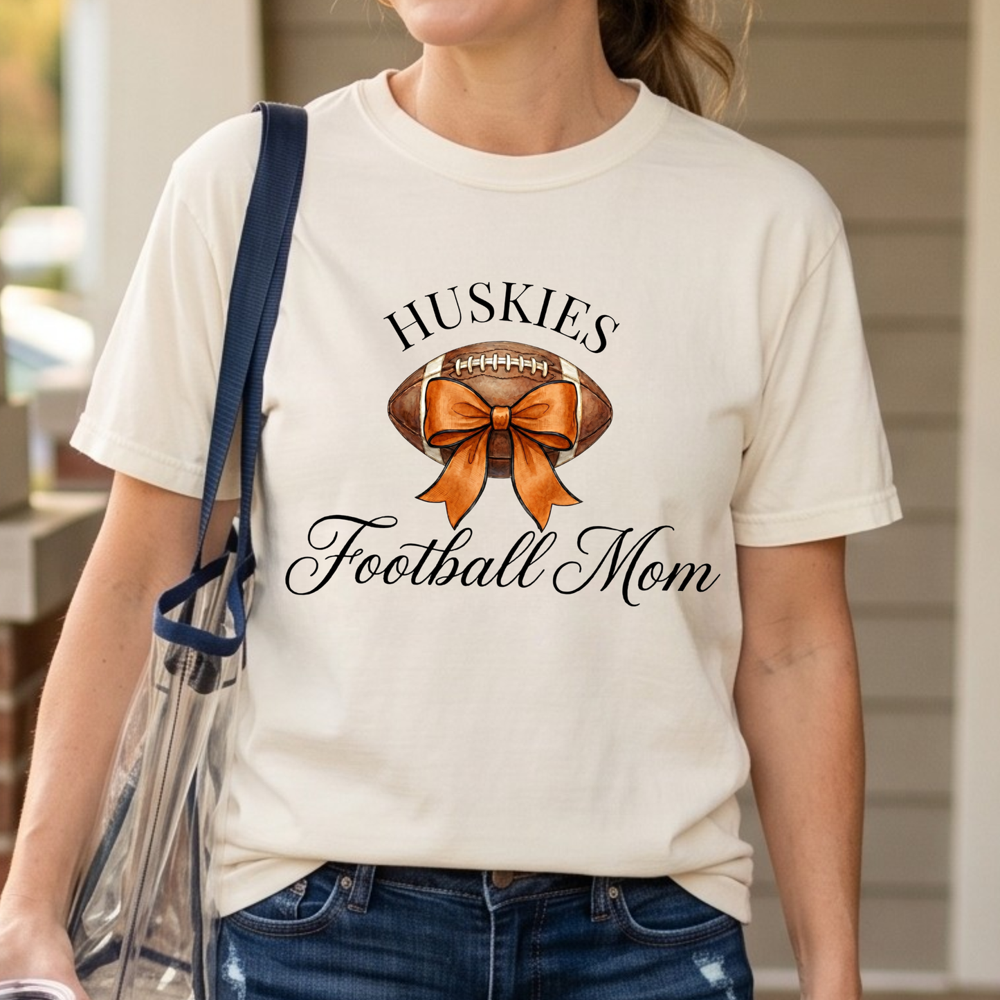 Huskies Football Mom graphic featuring watercolor football with orange coquette bow and elegant script typography