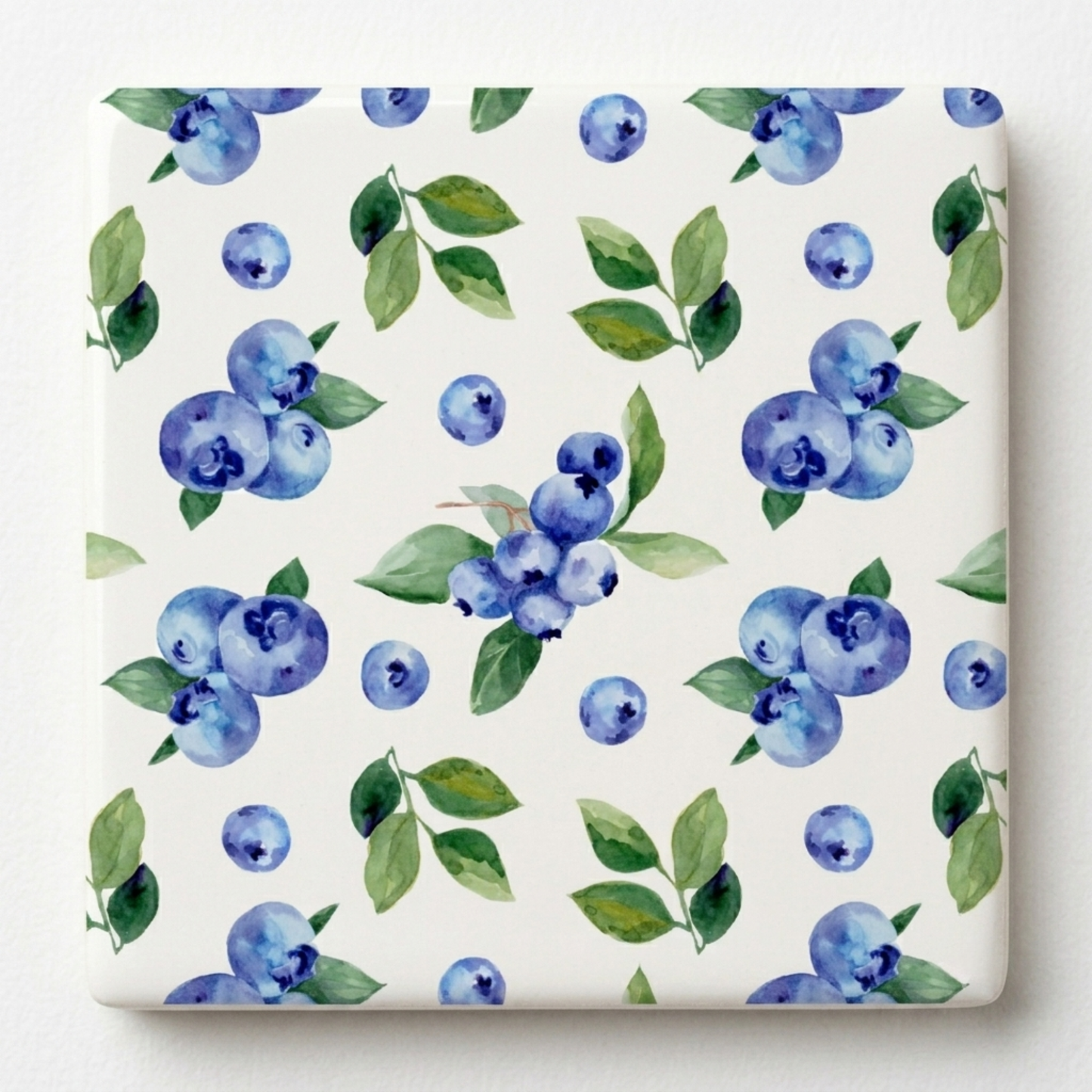 Pattern of blueberries and green leaves on a white background