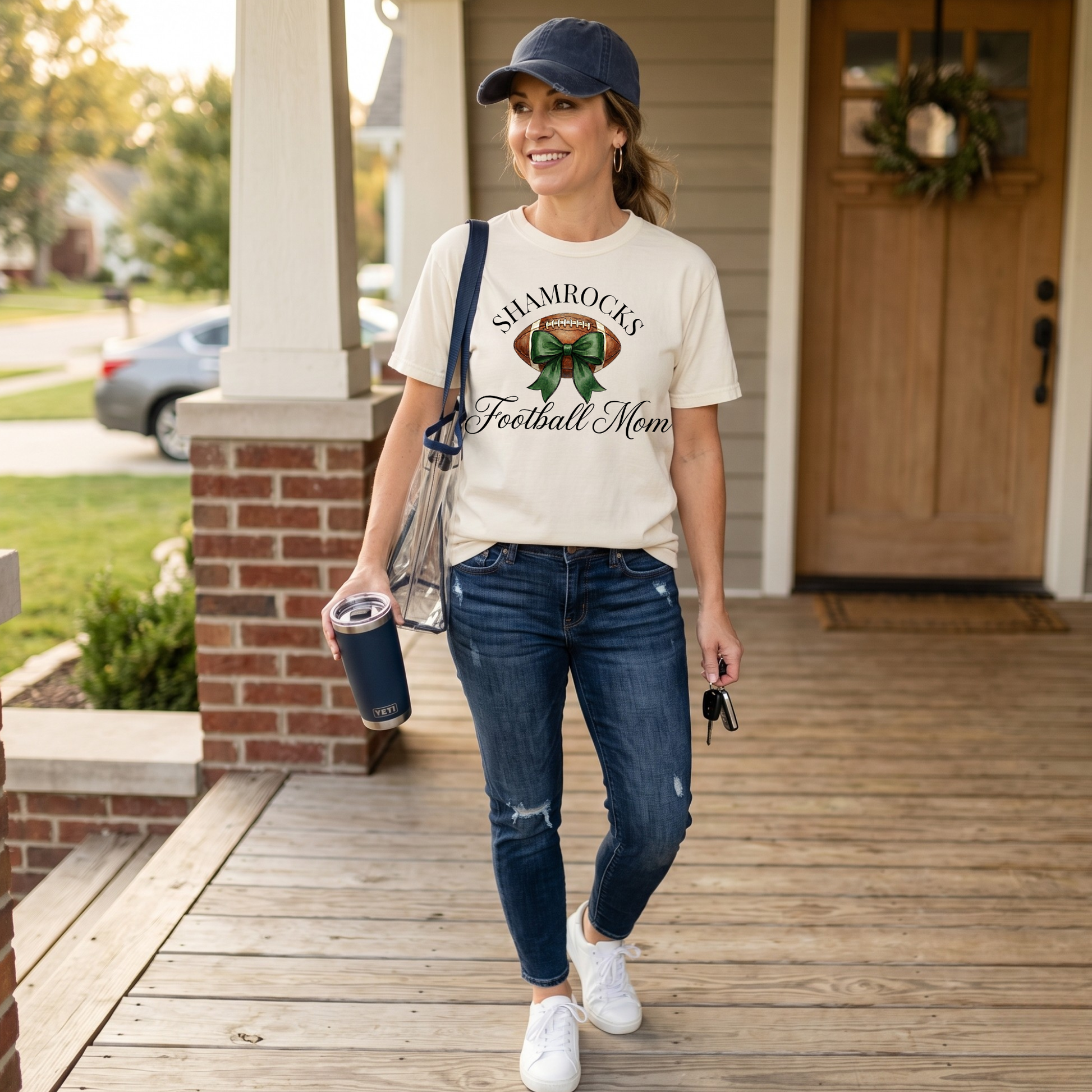 Westfield Shamrocks Football Mom Coquette Bow Tee featuring watercolor football and green bow graphic on ivory Comfort Colors shirt