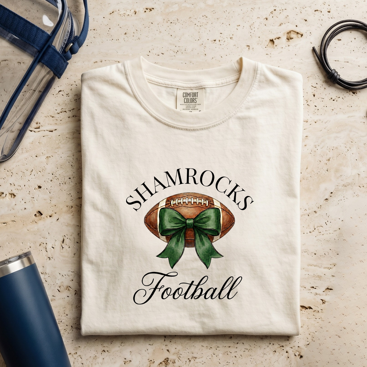 Folded t-shirt with shamrock and football design on a textured surface