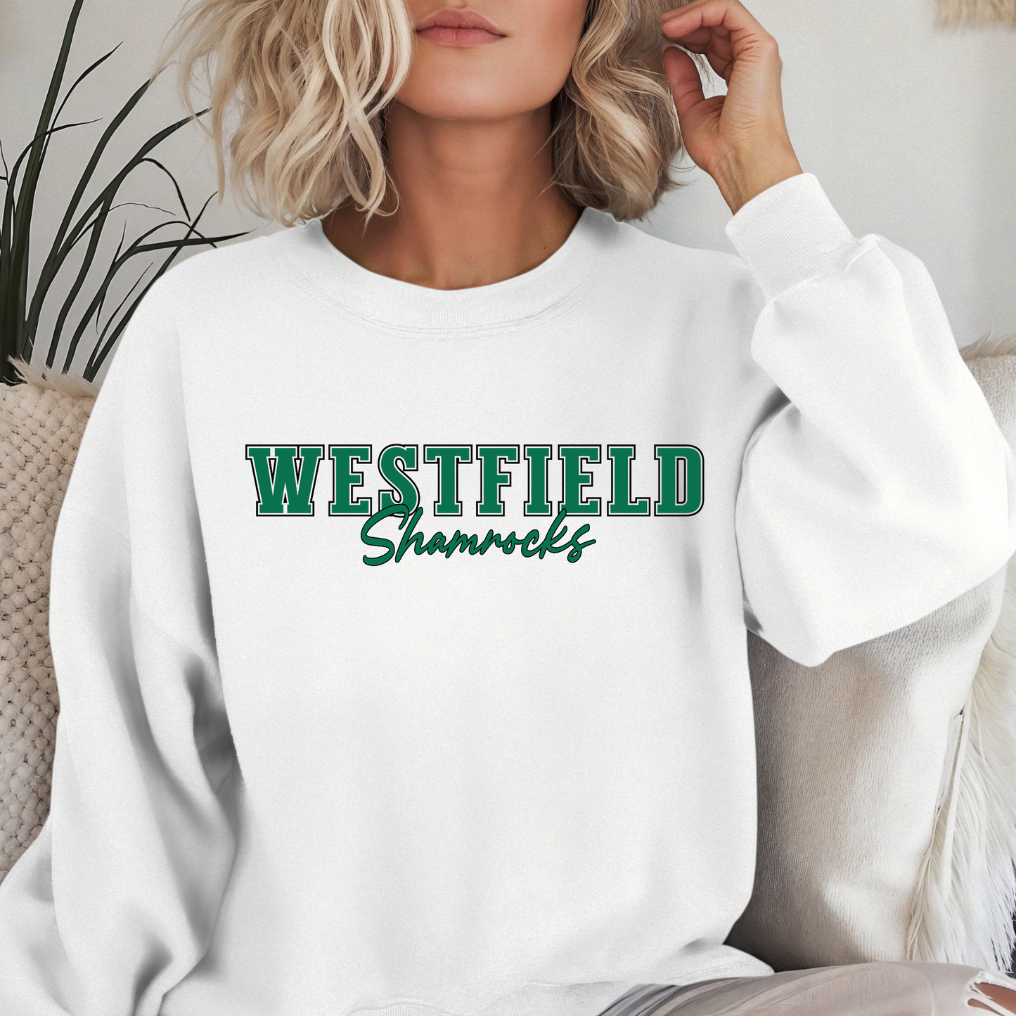 Woman wearing a white Westfield Shamrocks Script Spirit Crewneck Sweatshirt featuring green varsity Westfield lettering with Shamrocks script design on a unisex sweatshirt.