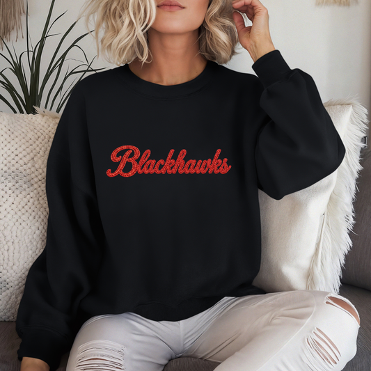 Close-up of Sheridan Blackhawks faux embroidered crewneck sweatshirt with red script lettering on black sweatshirt