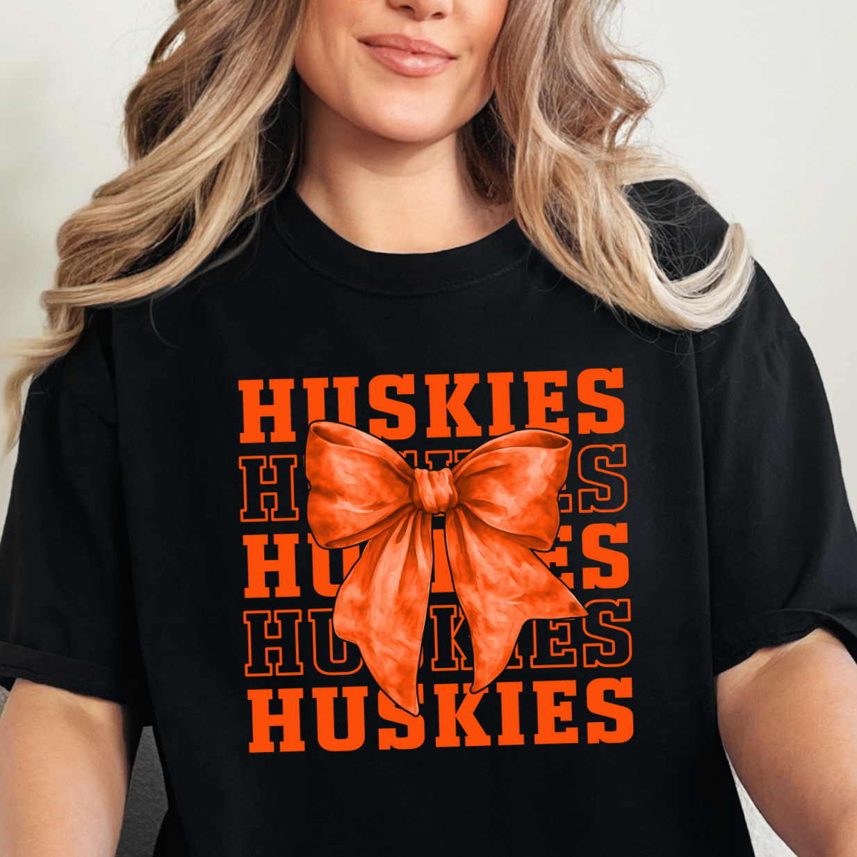 Hamilton Heights Huskies stacked varsity typography design with oversized orange coquette bow for trendy school spirit apparel
