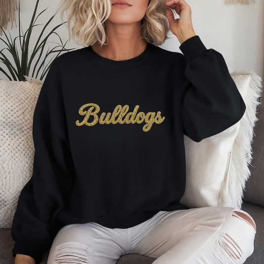 Woman wearing a black Lapel Bulldogs Faux Embroidered Crewneck Sweatshirt featuring a gold faux embroidered Bulldogs script design for school spirit apparel.
