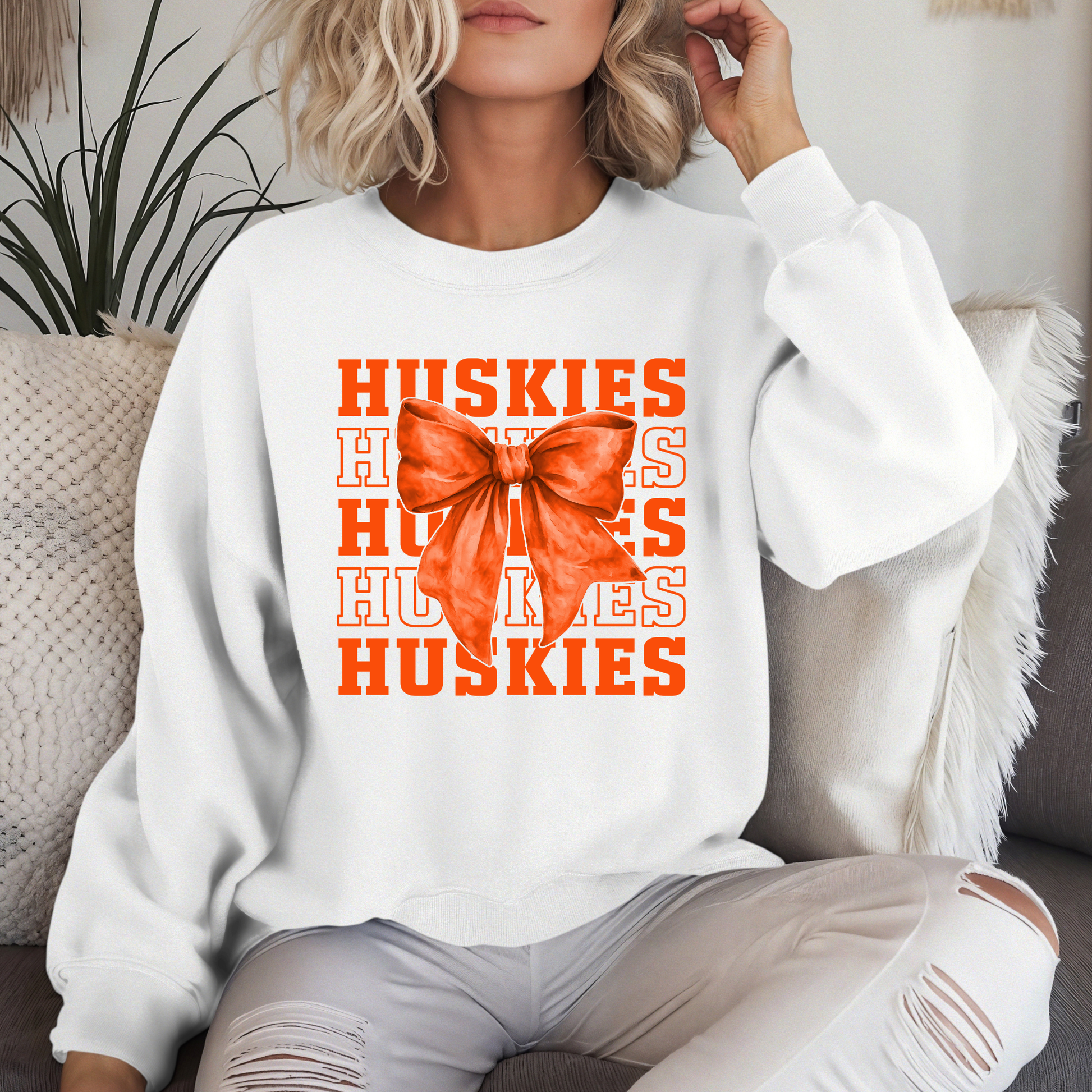 Hamilton Heights Huskies coquette bow crewneck sweatshirt featuring layered varsity typography and oversized orange bow graphic on white sweatshirt