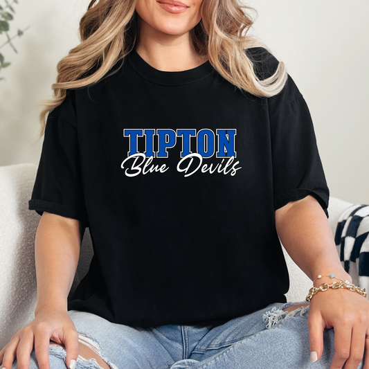 Woman wearing a black Tipton Blue Devils Script Spirit Shirt featuring bold Tipton lettering and Blue Devils script design in royal blue and white school colors.