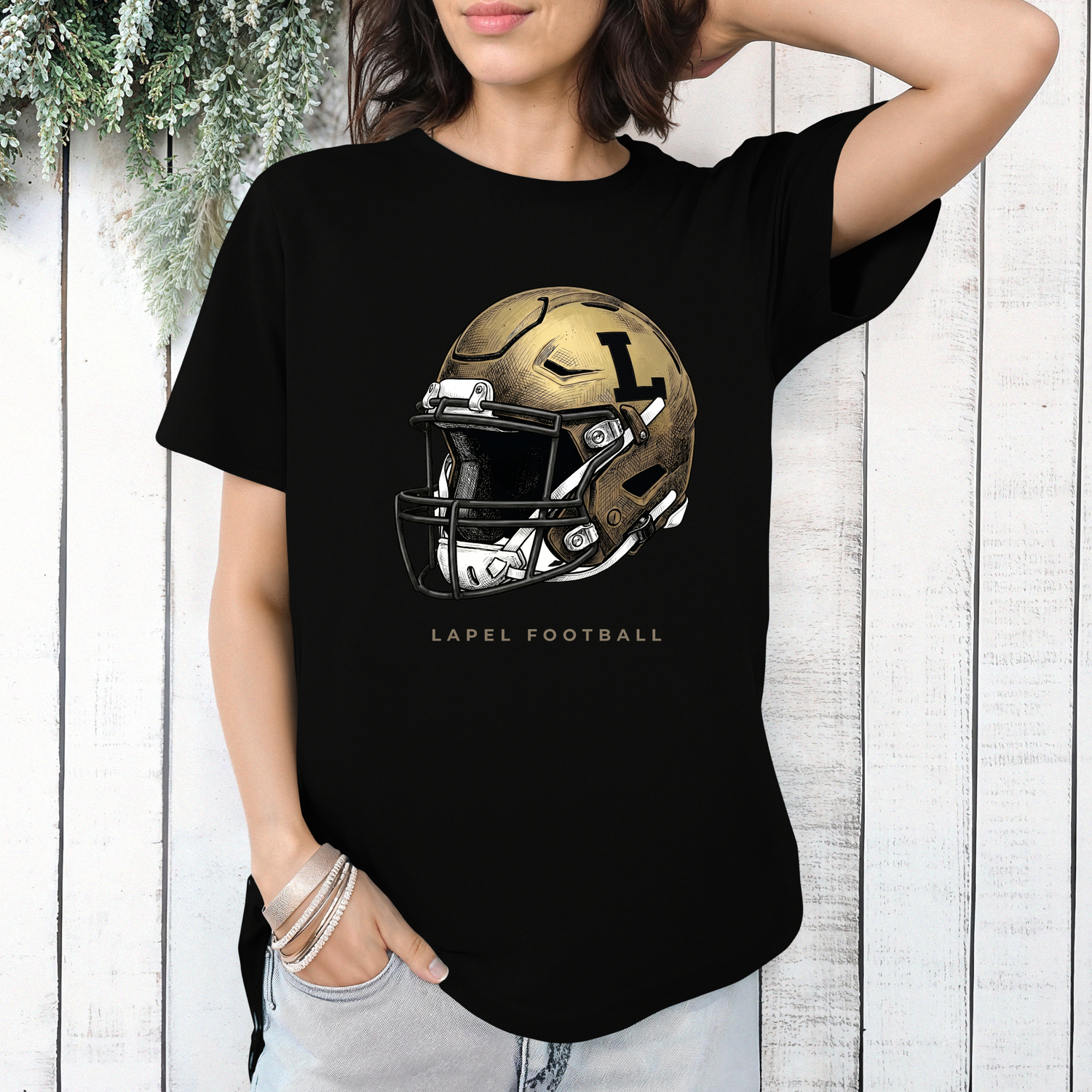 A person wearing a black t-shirt featuring a detailed gold football helmet graphic with 'LAPEL FOOTBALL' text.