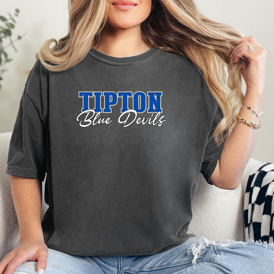 Woman wearing a dark grey Tipton Blue Devils Script Spirit Shirt featuring bold Tipton lettering and Blue Devils script design in royal blue and white school colors.