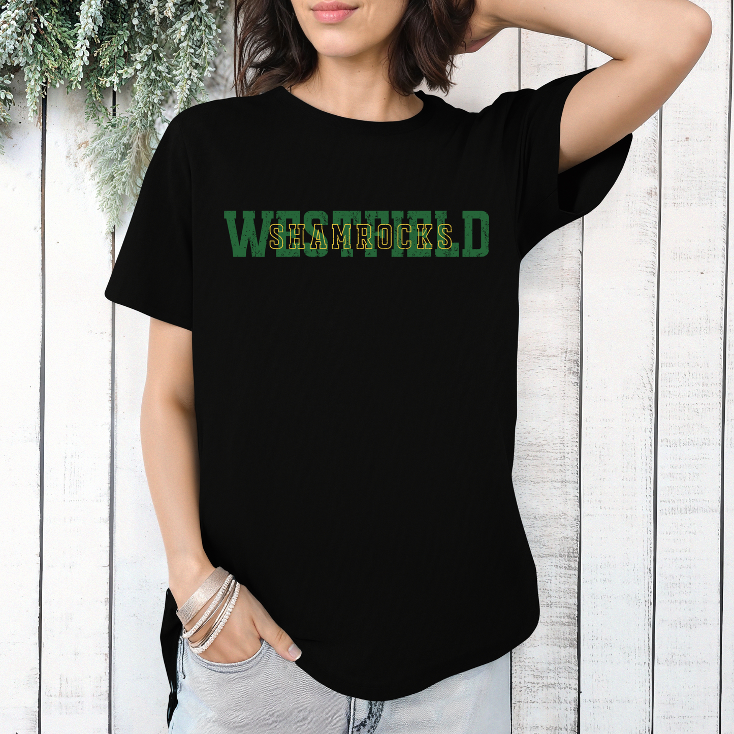 A person wearing a black t-shirt featuring 'WESTFIELD' in green block letters with 'SHAMROCKS' layered in a gold-outlined font.