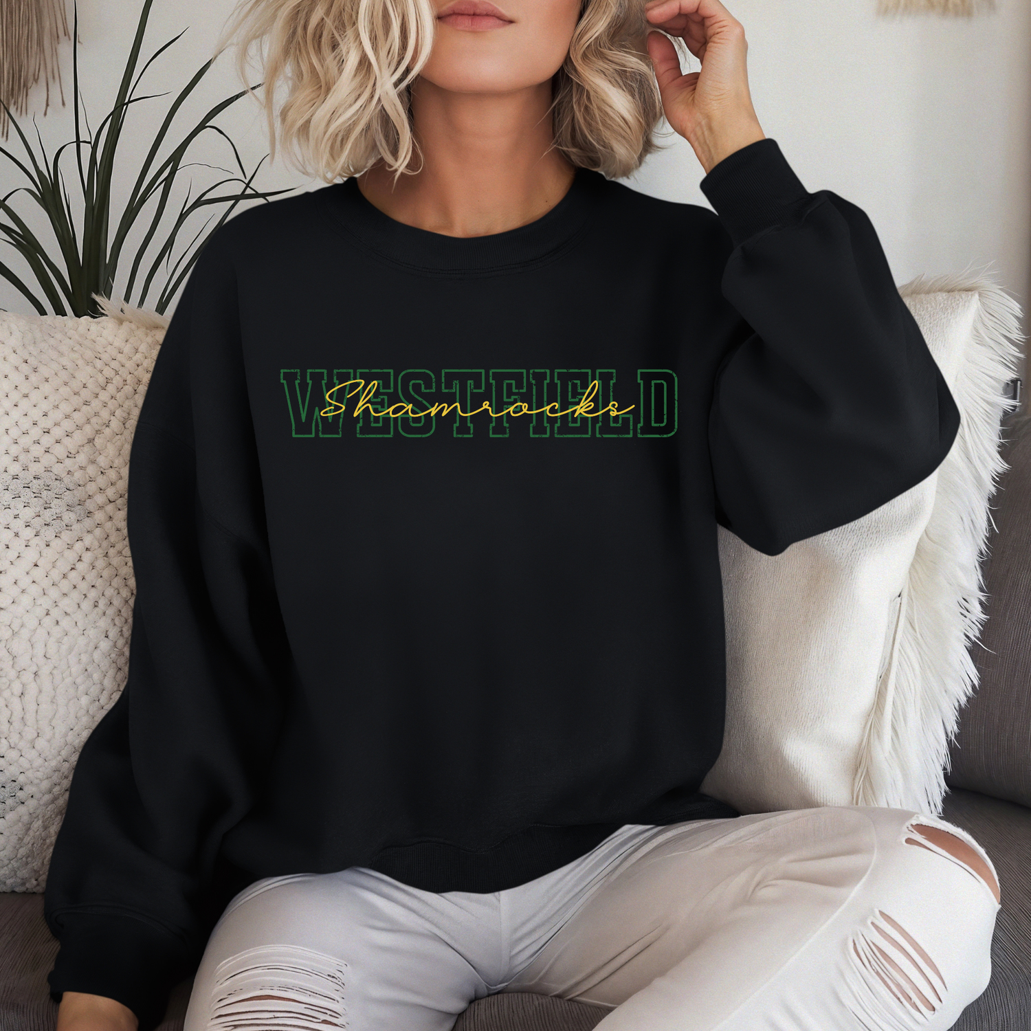 A person wearing a black crewneck sweatshirt featuring "WESTFIELD" in green block letters with the word "Shamrocks" layered in a gold script font.
