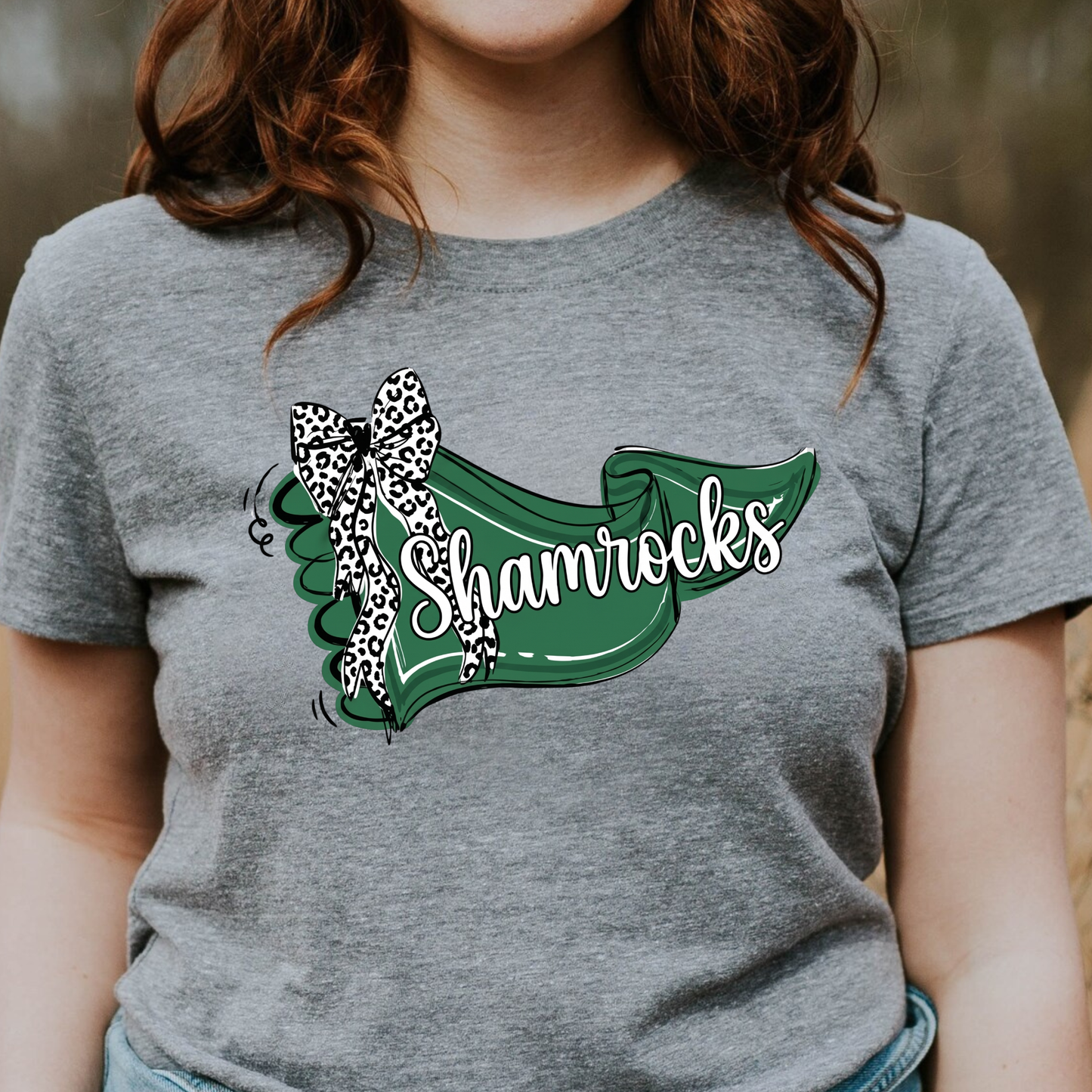 A close-up graphic showing a green banner with 'Shamrocks' text and a leopard-print bow accent.
