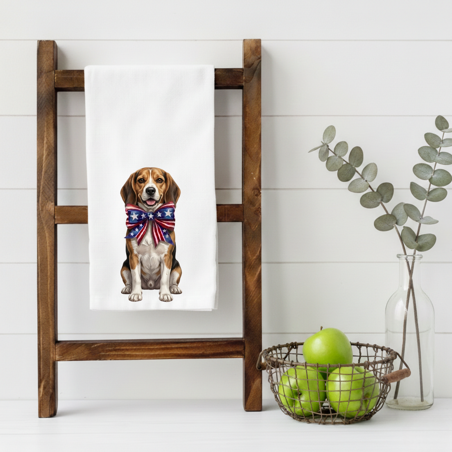 Towel with a Beagle dog wearing a patriotic bandana on a wooden ladder against a white wall.