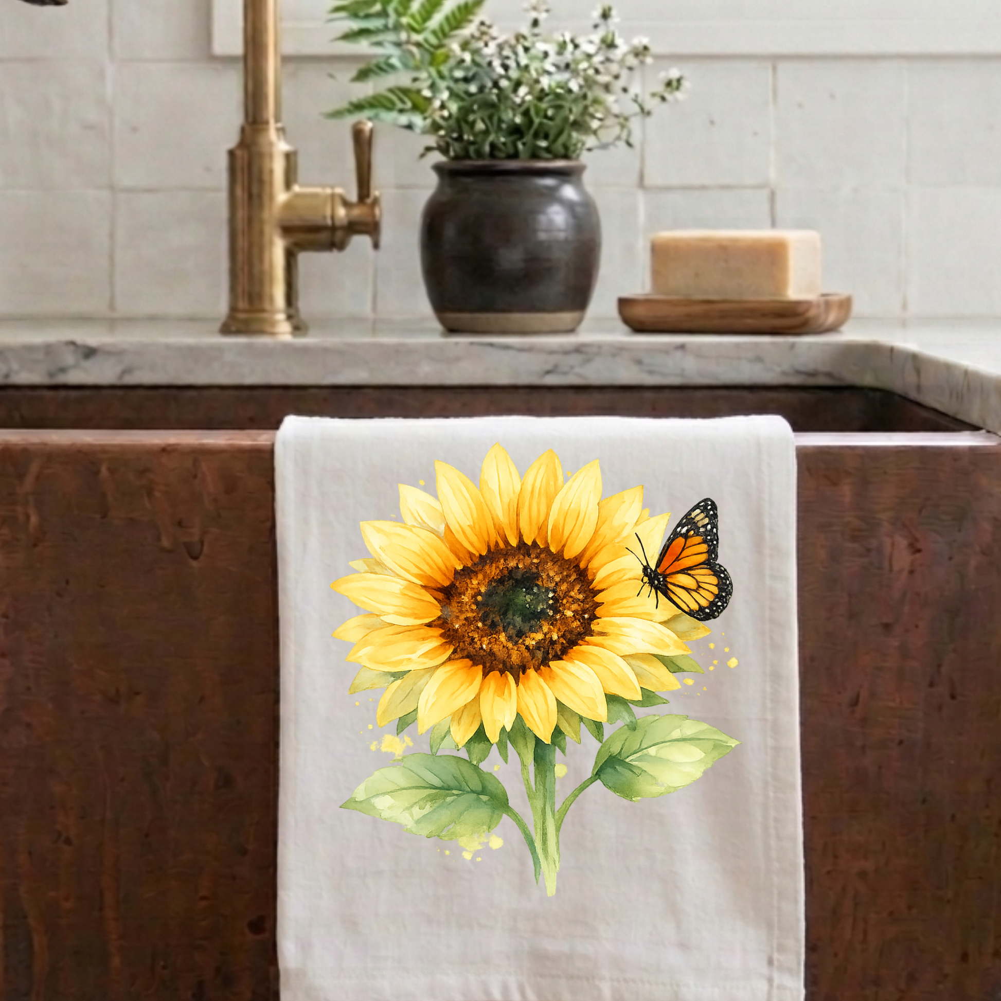 Sunflower and monarch butterfly watercolor tea towel displayed on a farmhouse kitchen sink as decorative kitchen decor.