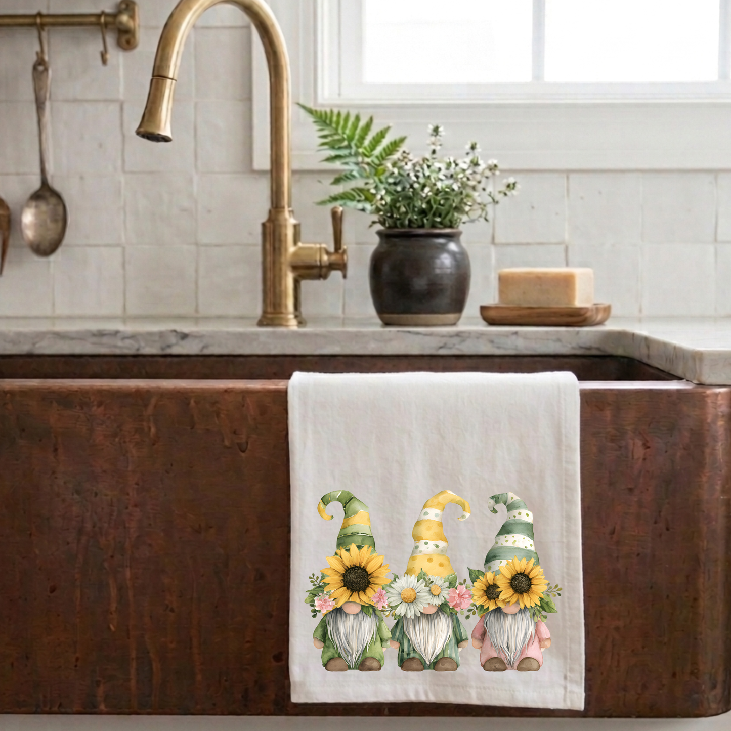 Cottagecore sunflower gnome tea towel hanging on a rustic copper farmhouse sink