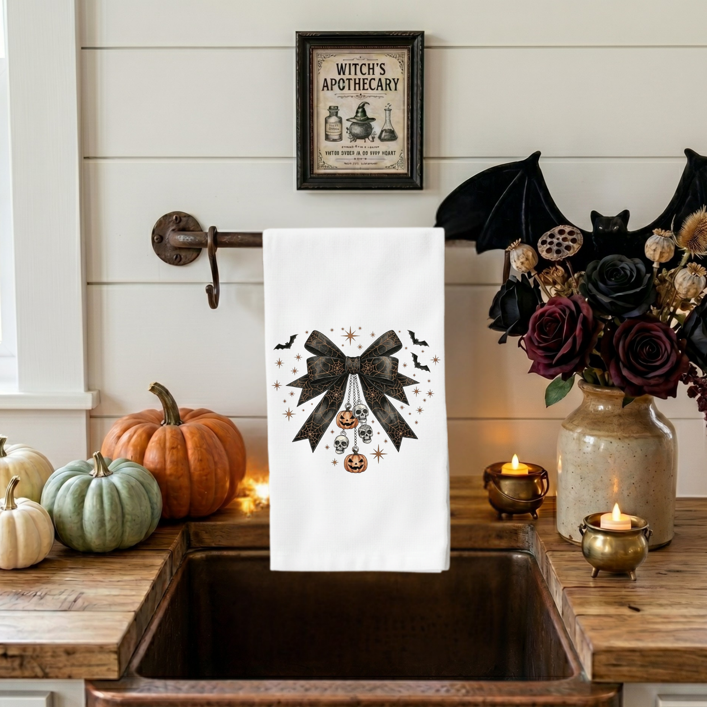 Gothic coquette Halloween kitchen towel featuring black lace bow with skull charms, pumpkin ornaments, bats, and vintage spooky decor artwork