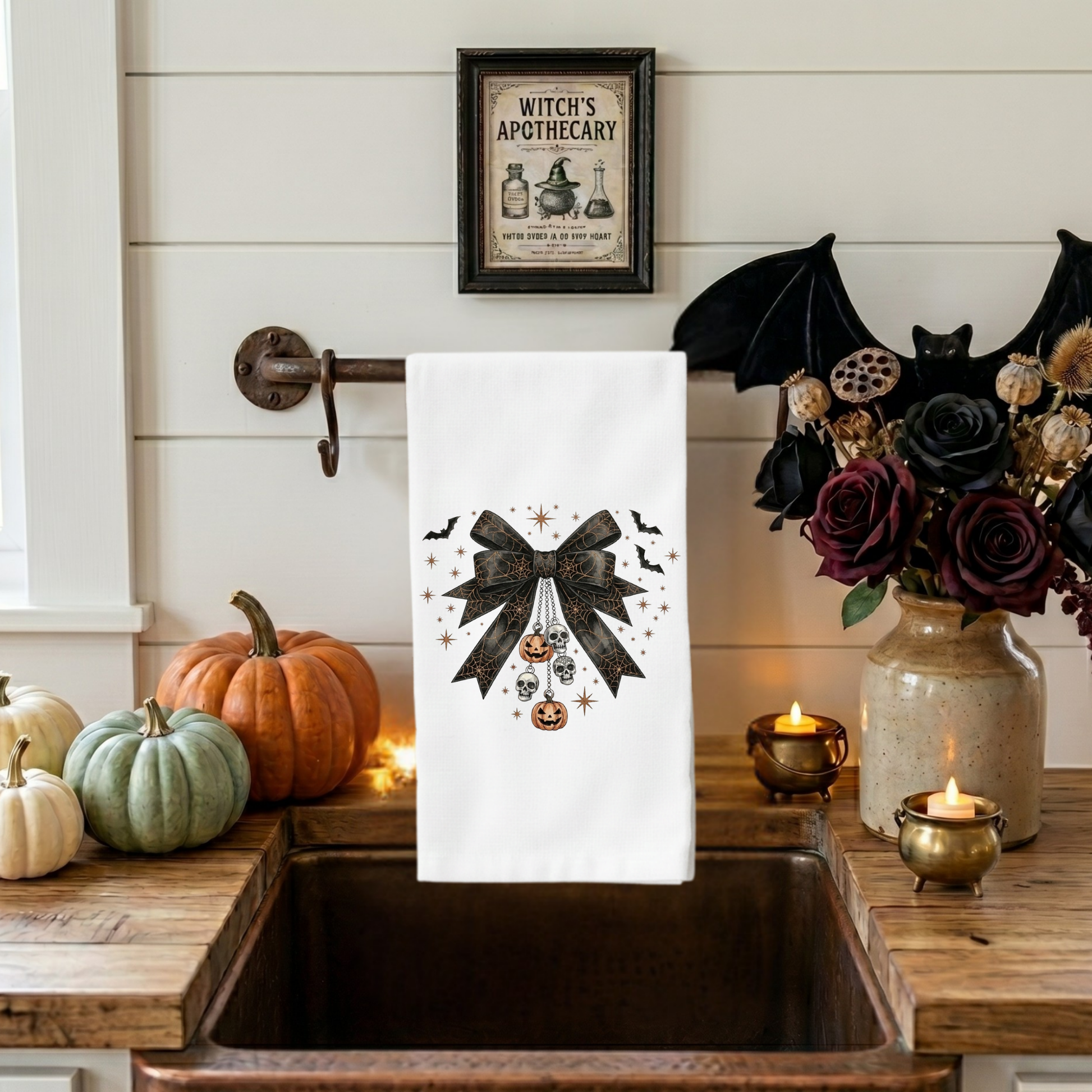 Gothic coquette Halloween kitchen towel featuring black lace bow with skull charms, pumpkin ornaments, bats, and vintage spooky decor artwork