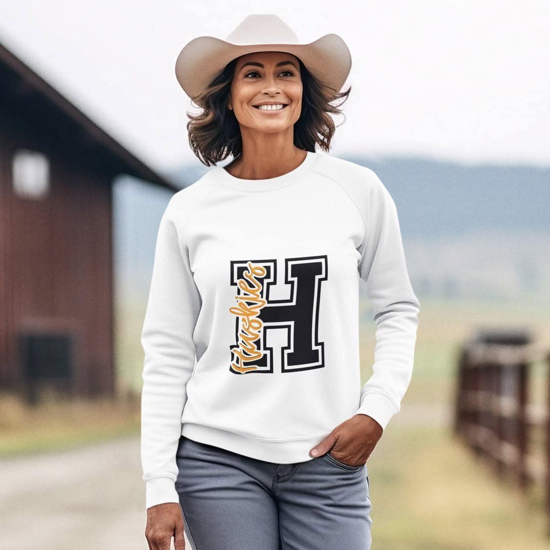 Woman wearing a Hamilton Heights Huskies H crewneck sweatshirt, black and white varsity letter design, school spirit wear.