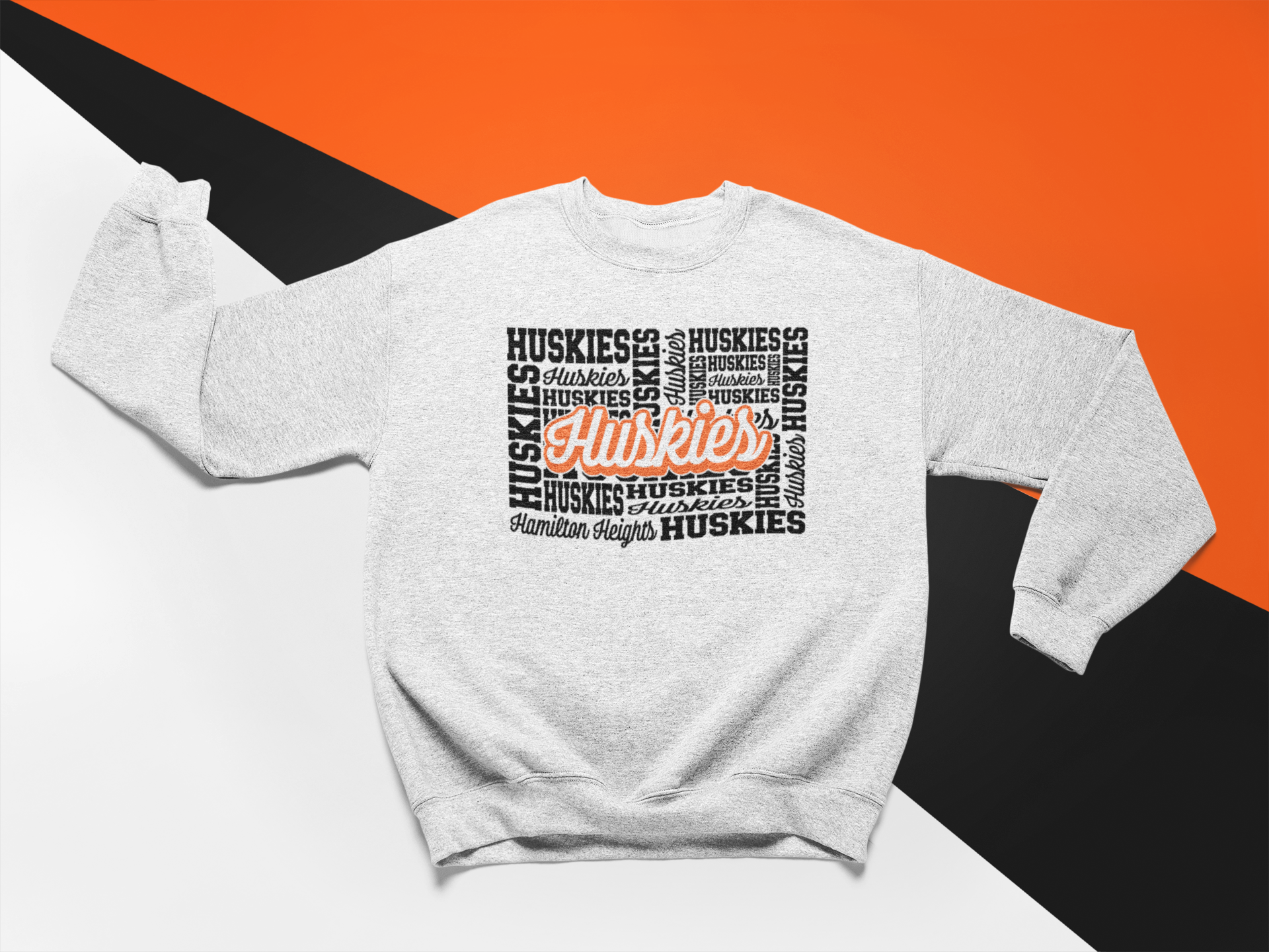 Woman wearing a Hamilton Heights Huskies Word Collage crewneck, black sweatshirt with bold orange and white typography.