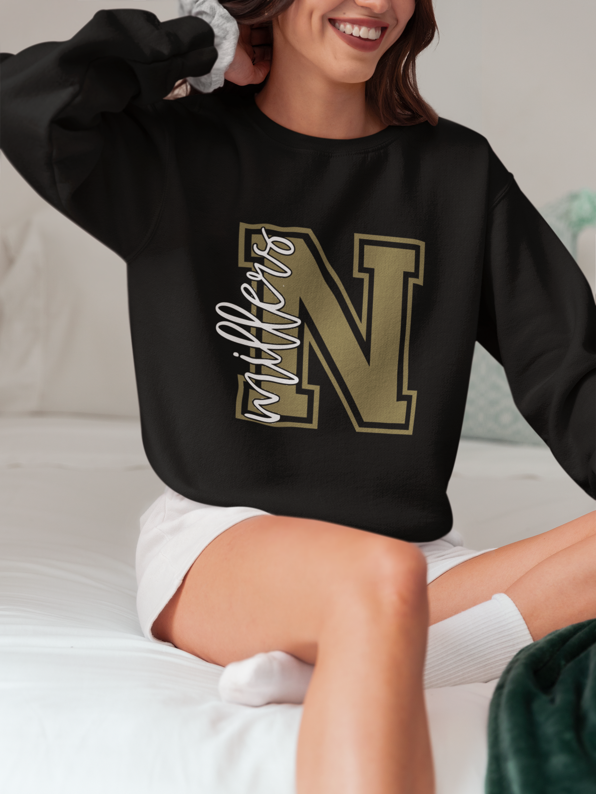 Woman wearing a black Noblesville Millers varsity letter N crewneck sweatshirt.