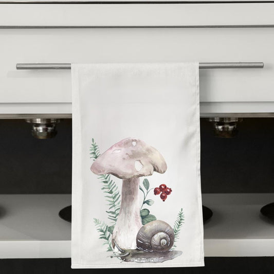 Kitchen towel with a mushroom design hanging on a cabinet handle.
