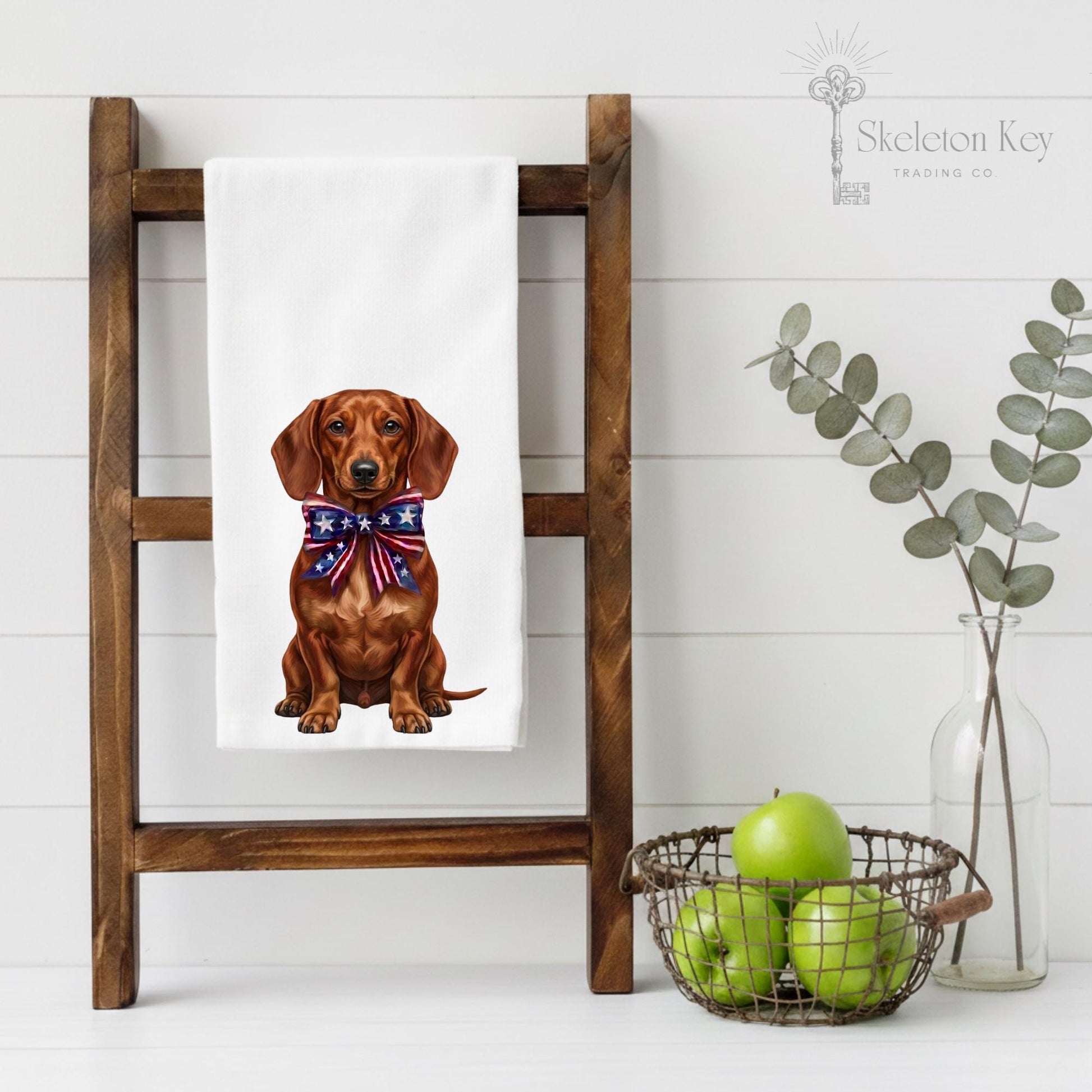 Dachshund with a bow tie on a towel hanging on a wooden ladder against a white wall.