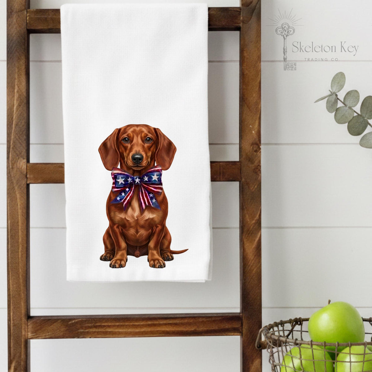 Towel with a dachshund wearing a patriotic bow tie on a wooden ladder.