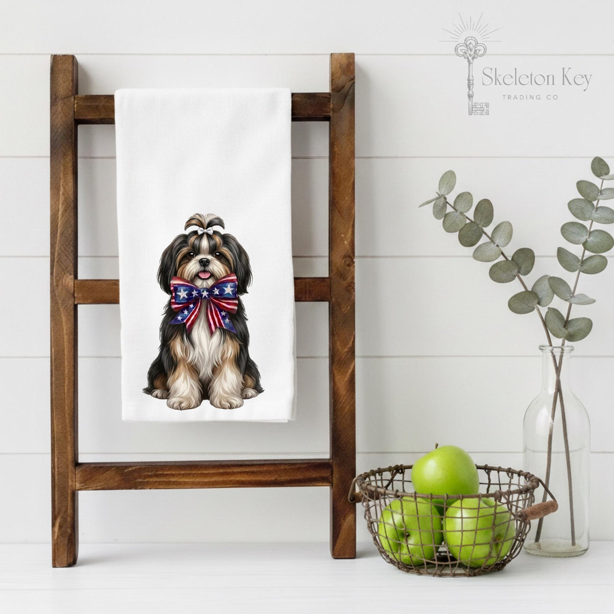 Towel with a dog design hanging on a wooden ladder against a white wall.