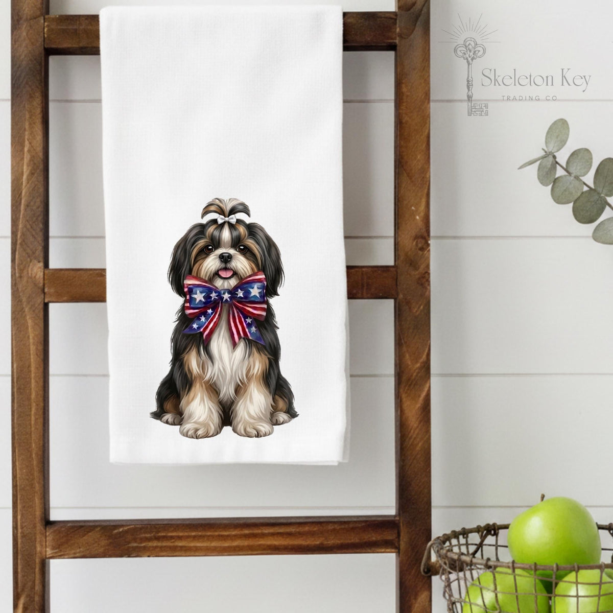 Towel with a dog design featuring an American flag bow, displayed on a wooden ladder.