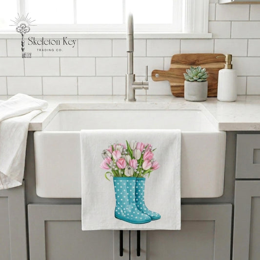 Kitchen sink with a towel hanging on the faucet showing a design of blue wellington boots with pink tulips.
