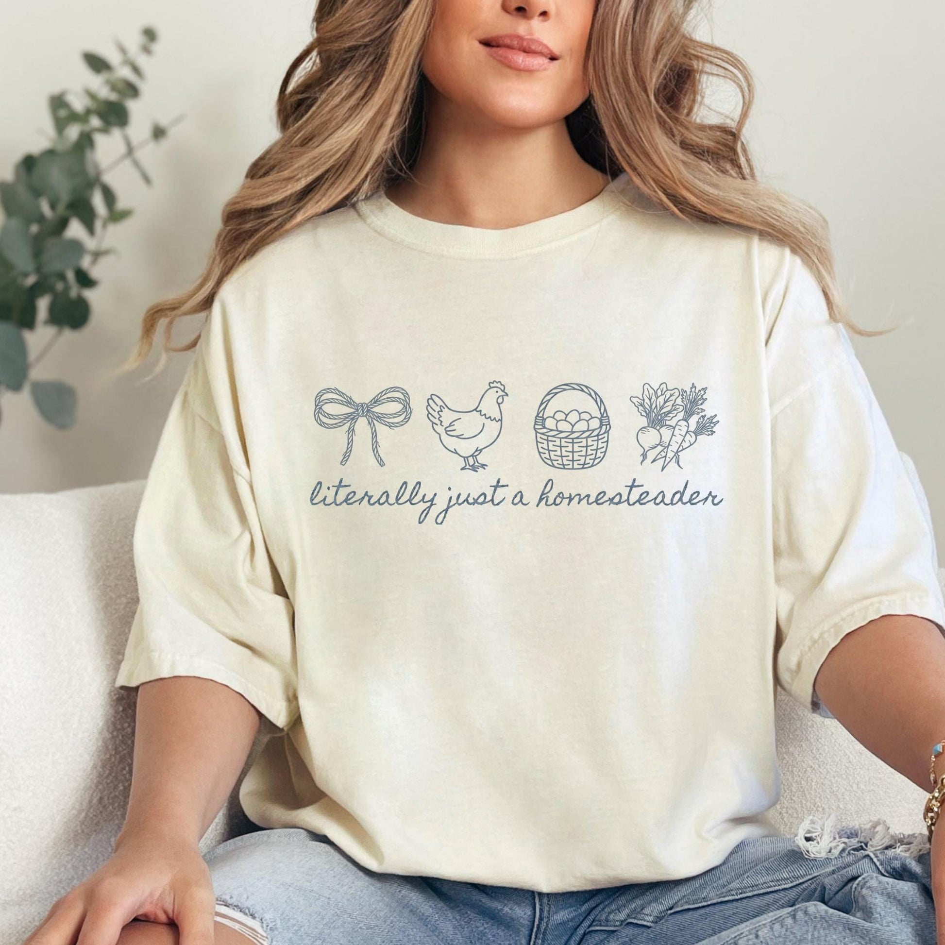 Person wearing a cream-colored t-shirt with farm-themed graphics and text.