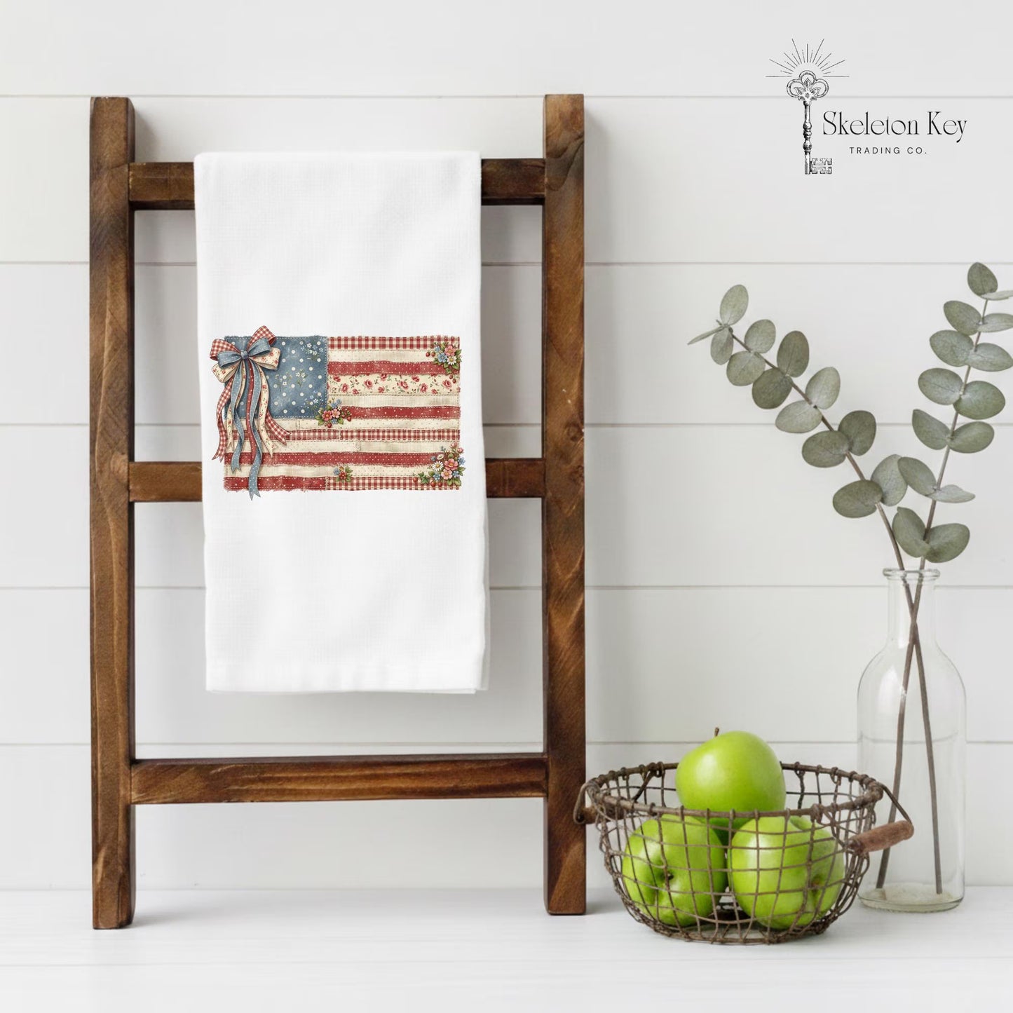 Patriotic farmhouse tea towel featuring vintage American flag design with flowers and rustic Americana decor
