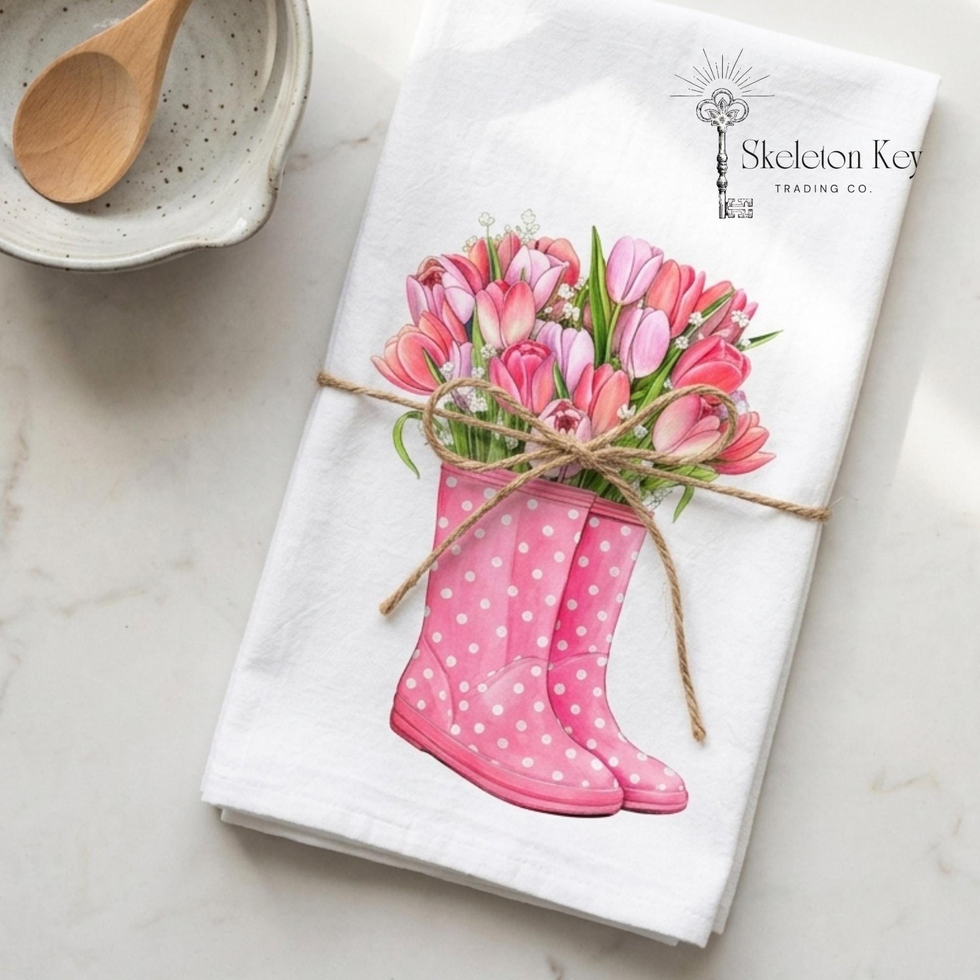 Towel with pink rain boots and tulips design on a marble surface