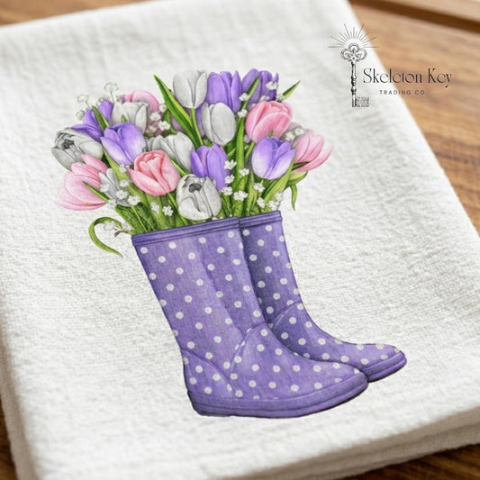 Purple polka dot boots with tulips on a white towel, brand 'Skeleton Key Trading Co' visible