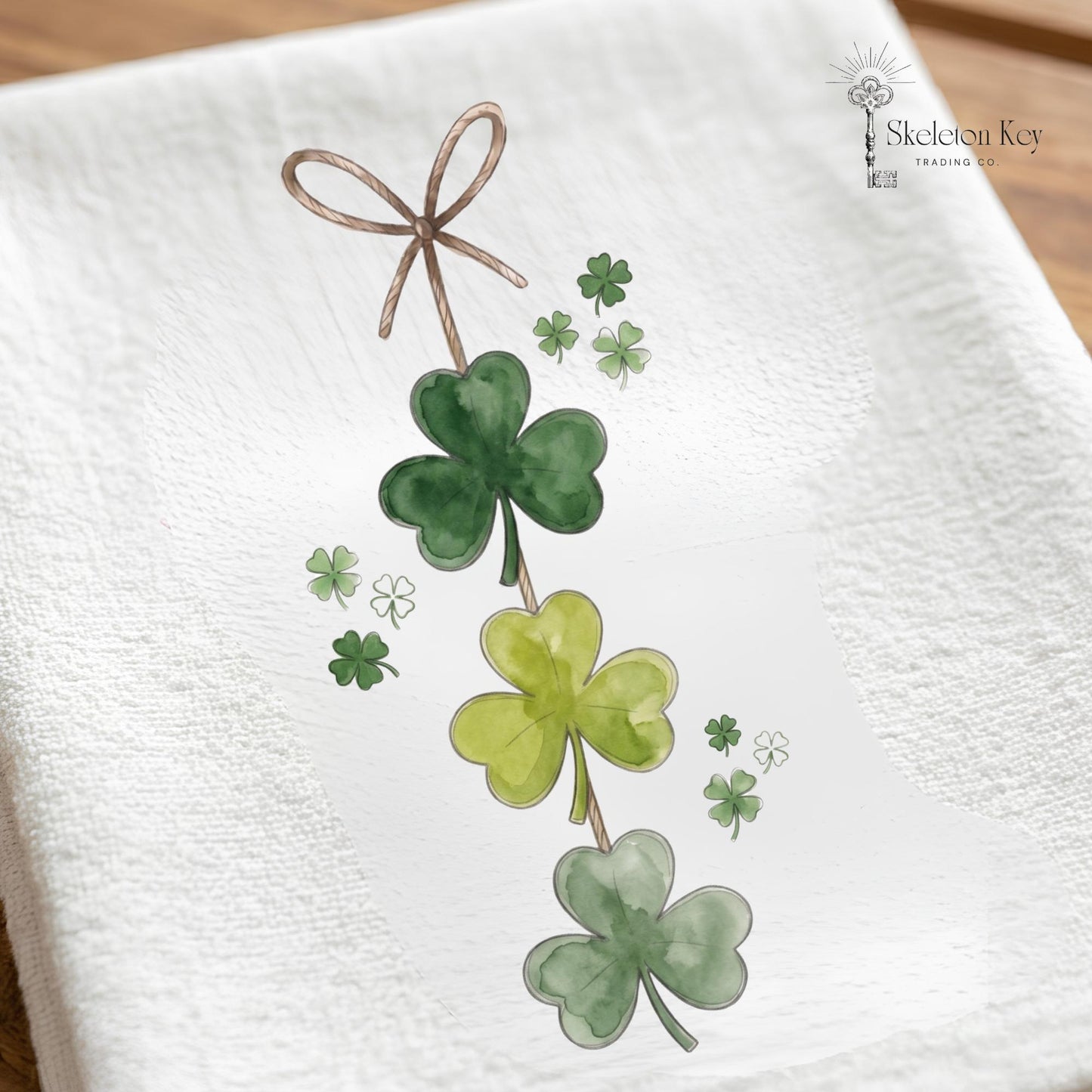 Four-leaf clover design on a white towel with 'Skeleton Key Trading Co' branding.