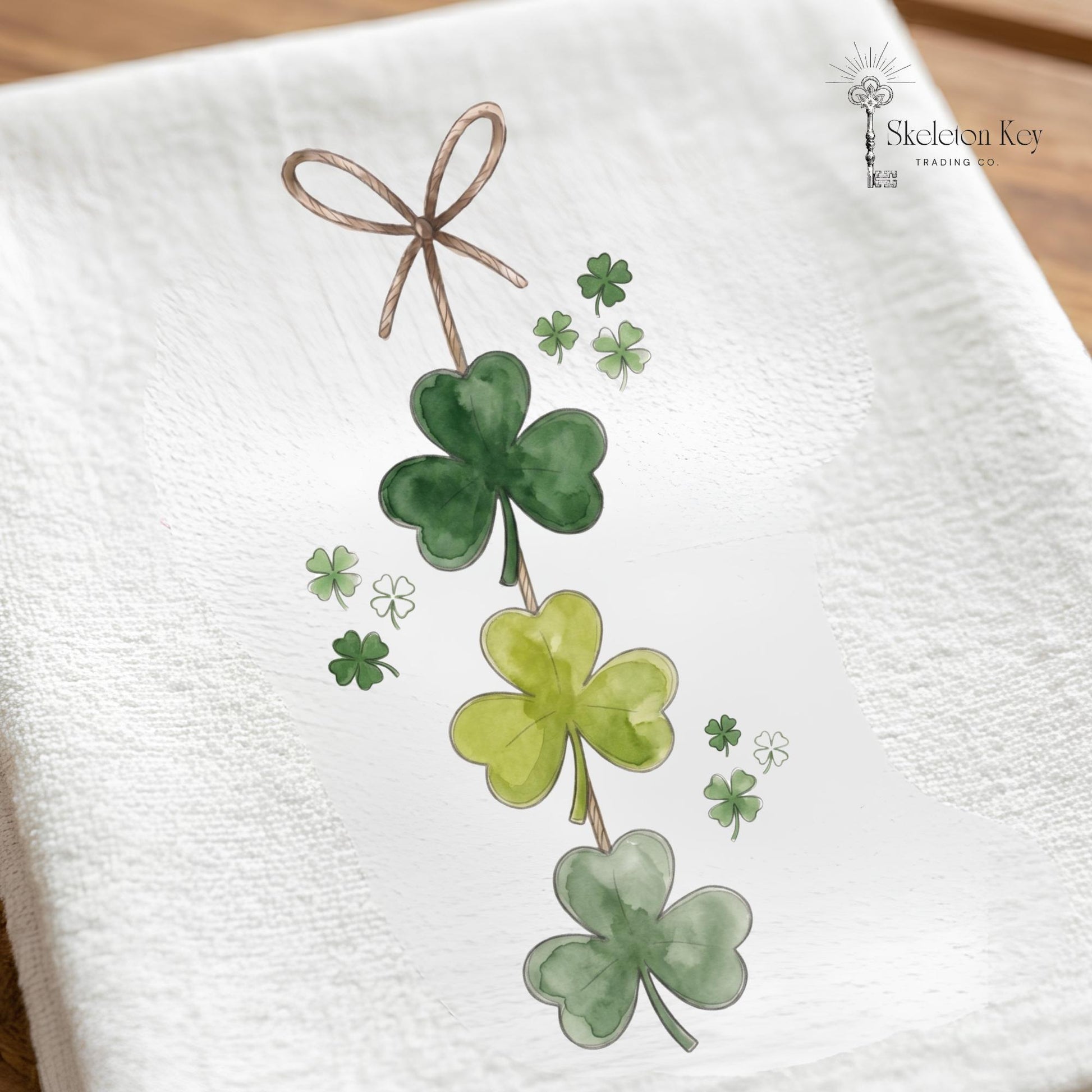 Four-leaf clover design on a white towel with 'Skeleton Key Trading Co' branding.