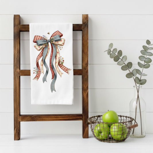 Patriotic farmhouse bow kitchen towel featuring vintage red white and blue ribbon artwork displayed on wooden ladder
