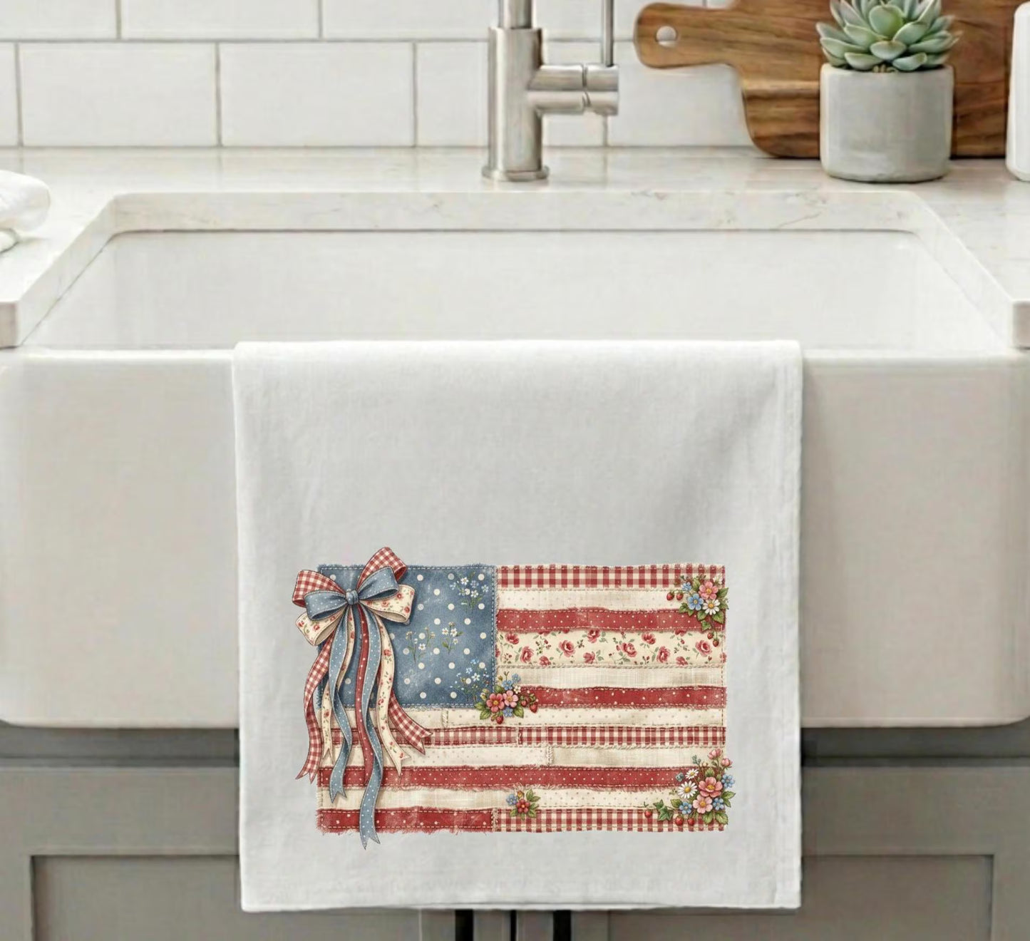 Vintage American flag kitchen towel with floral accents and patriotic ribbon displayed on farmhouse sink