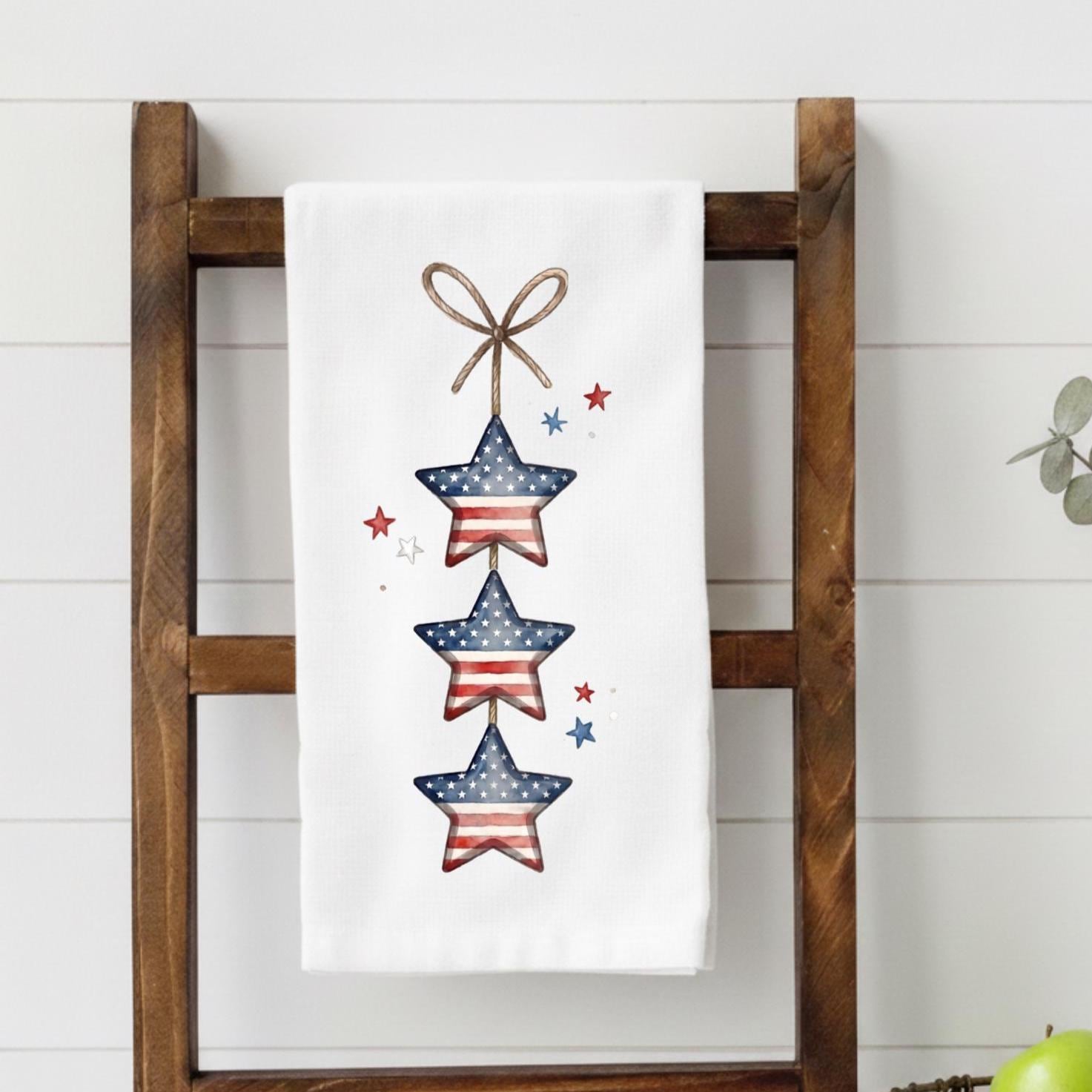 Decorative towel with star design hanging on a wooden ladder against a white wall.