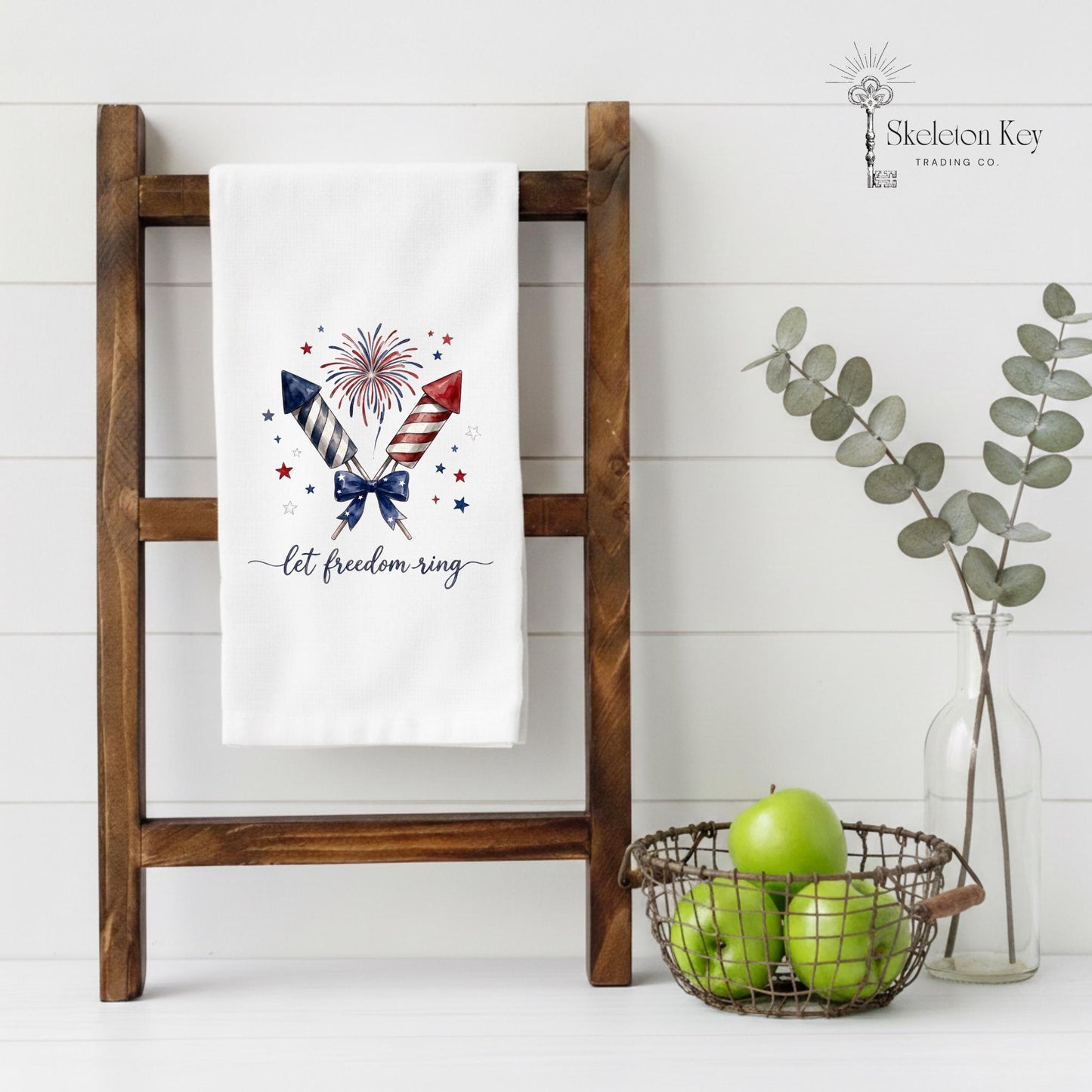 Decorative towel with patriotic design on a wooden ladder against a white wall.