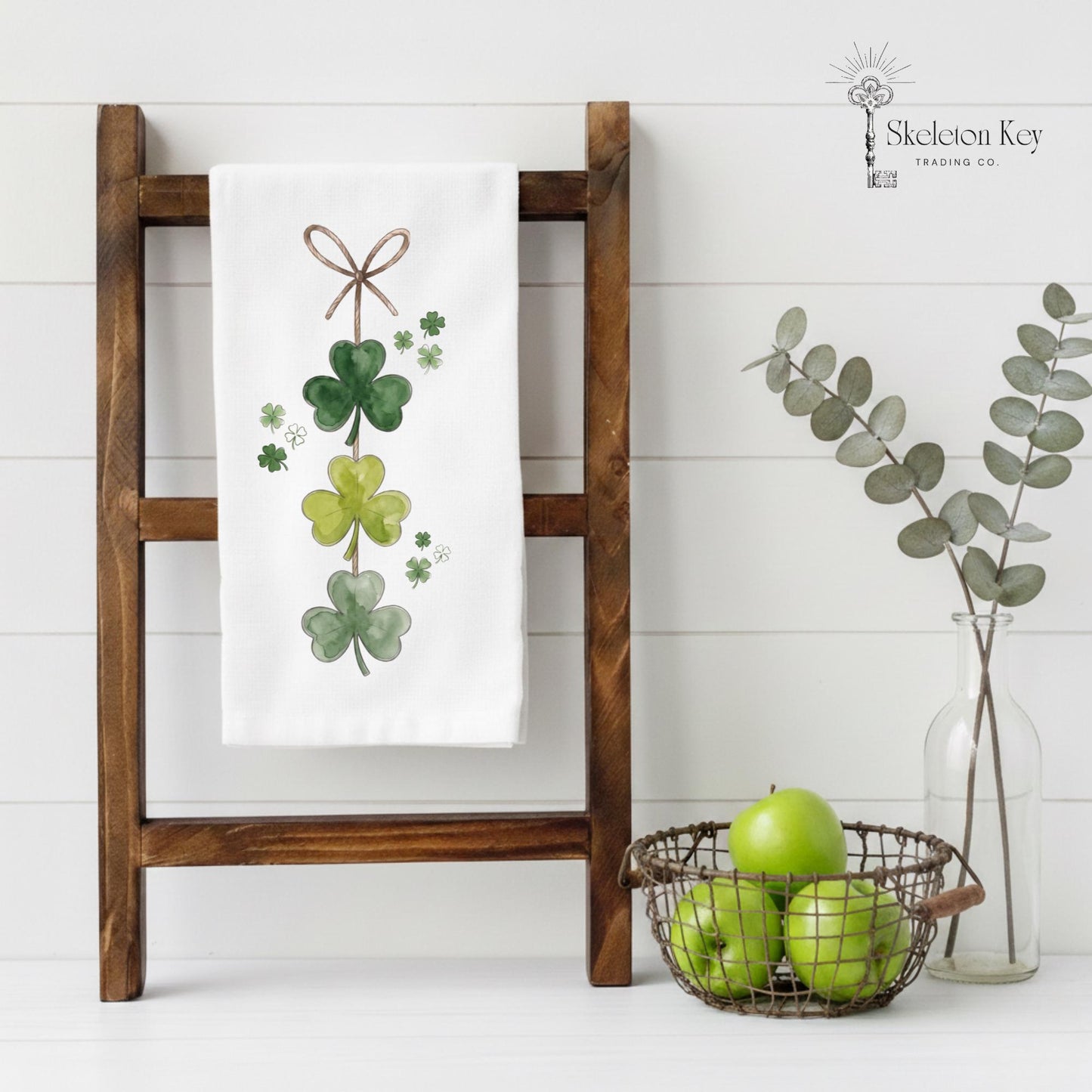 Decorative towel with shamrock design on a wooden ladder against a white background.